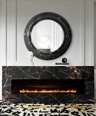 Entré moderne pejs med marmor surround og rundt sort indrammet spejl