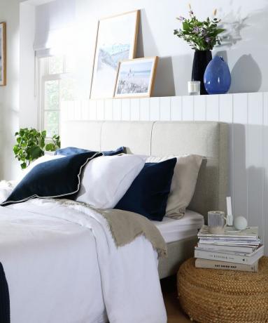 Blå og hvit soveromsinnredning med hylle over sengegavl