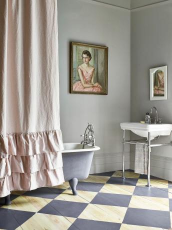 bagno con vasca e lavabo freestanding e pavimento dipinto