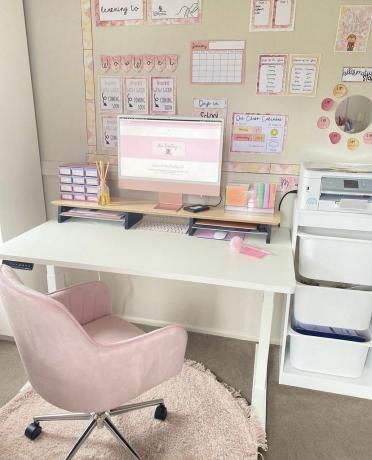 Vaaleanpunainen tuoli valkoisella työpöydällä