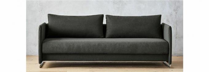 Un divano letto grigio scuro contemporaneo in una stanza con un pavimento in legno - CB2 Tandom Sleeper Sofa