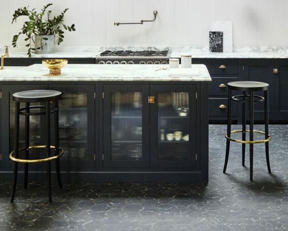 sorte sekskantede marmoreffekt gulvfliser i et marineblå køkken med ø og barstole af Carpetright