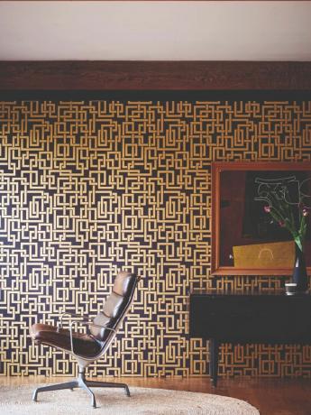 Papel de parede impresso dos anos setenta em home office com cadeira de couro preta