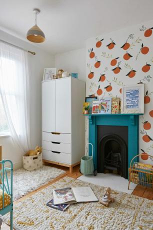 dormitorio para niños con una pared de características divertidas, chimenea y armario para niños