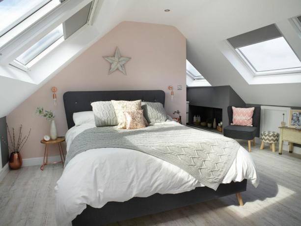 Jenny Weston Loft: pastellrosa Schlafzimmer in einem Loft mit grauem Bett und großen Dachfenstern