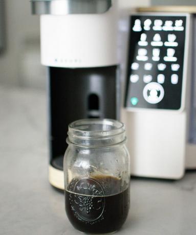 हीदर बिएन ब्रूवी कॉफी मेकर का उपयोग करके कांच के कंटेनर में गर्म कॉफी बना रही हैं